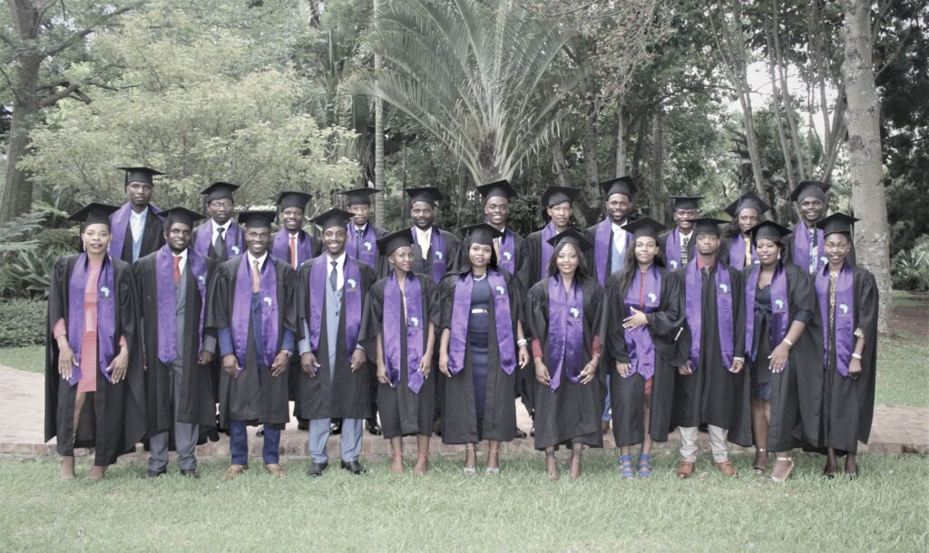 African Christian College graduating class of 22 graduates from 8 nations in their robes, hats of knowledge, and purple ACC sashes.