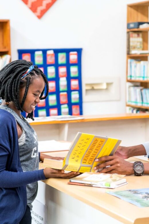 Thebe working in library, checking out a book.