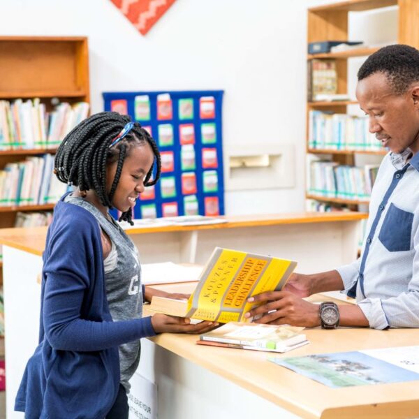 Thebe working in library, checking out a book.