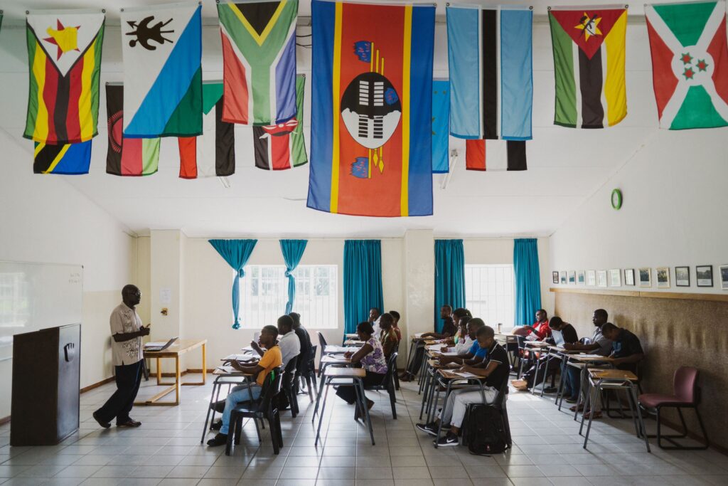 Alumni flags hanging above students during class.