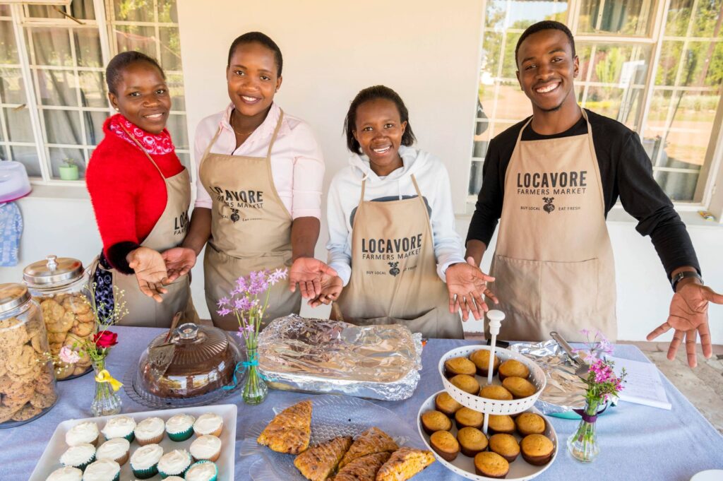 Four students working at a Locavore Market event.